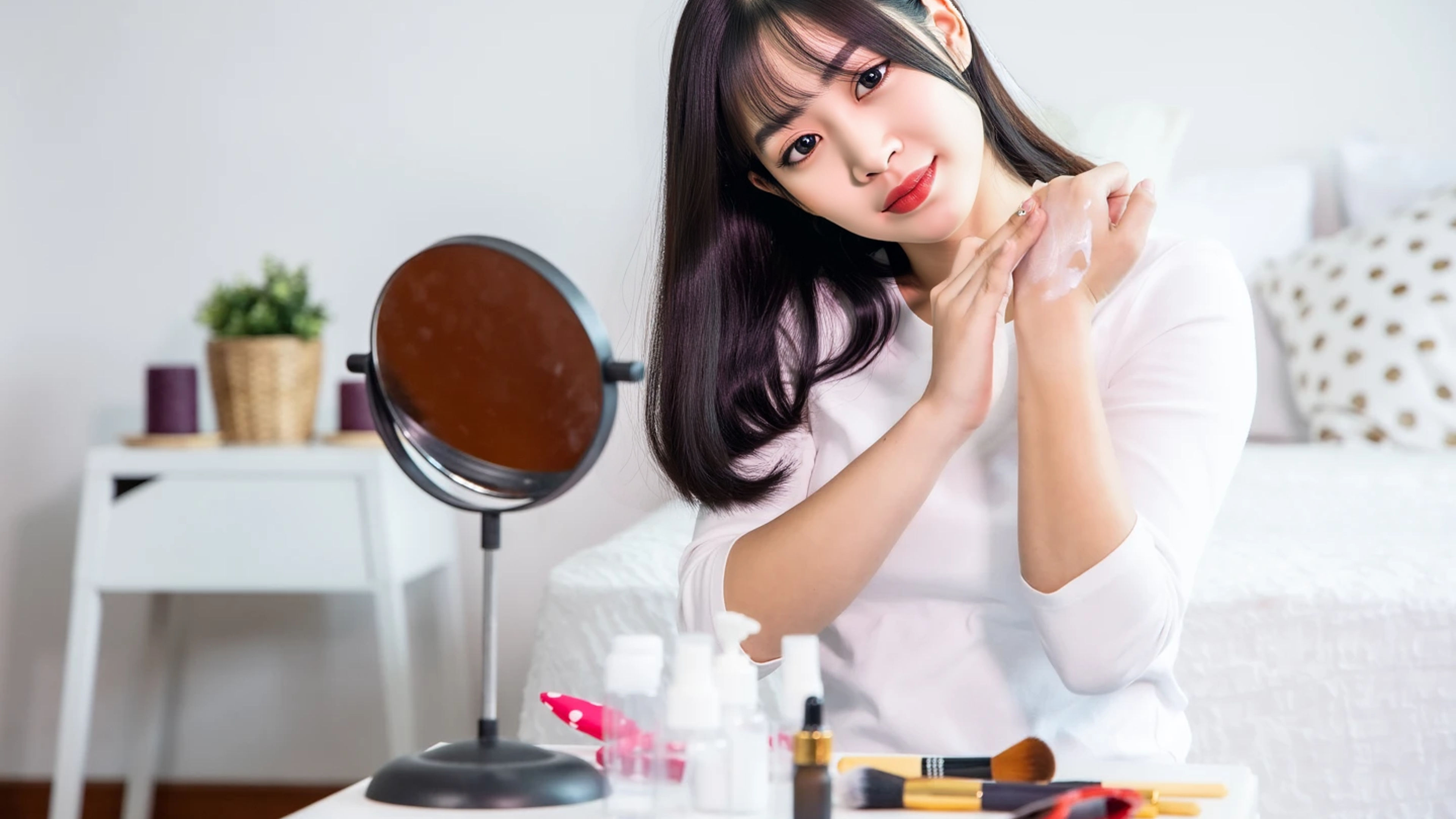Portrait of young Asian woman applying cosmetic at home.