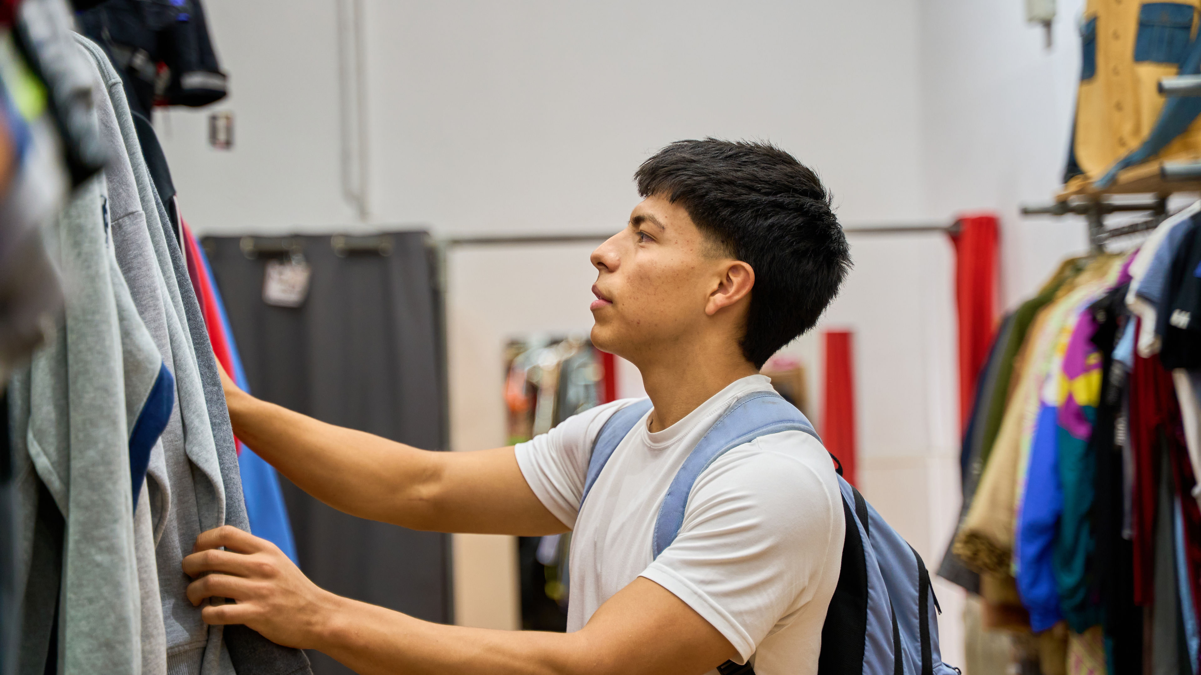 Young man selecting dresses