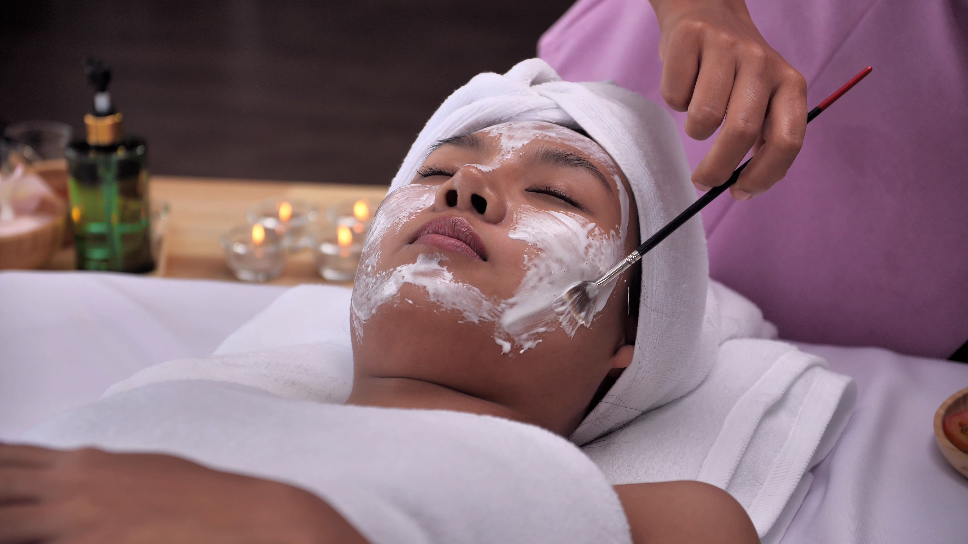 A woman trying a face mask in a beauty salon.