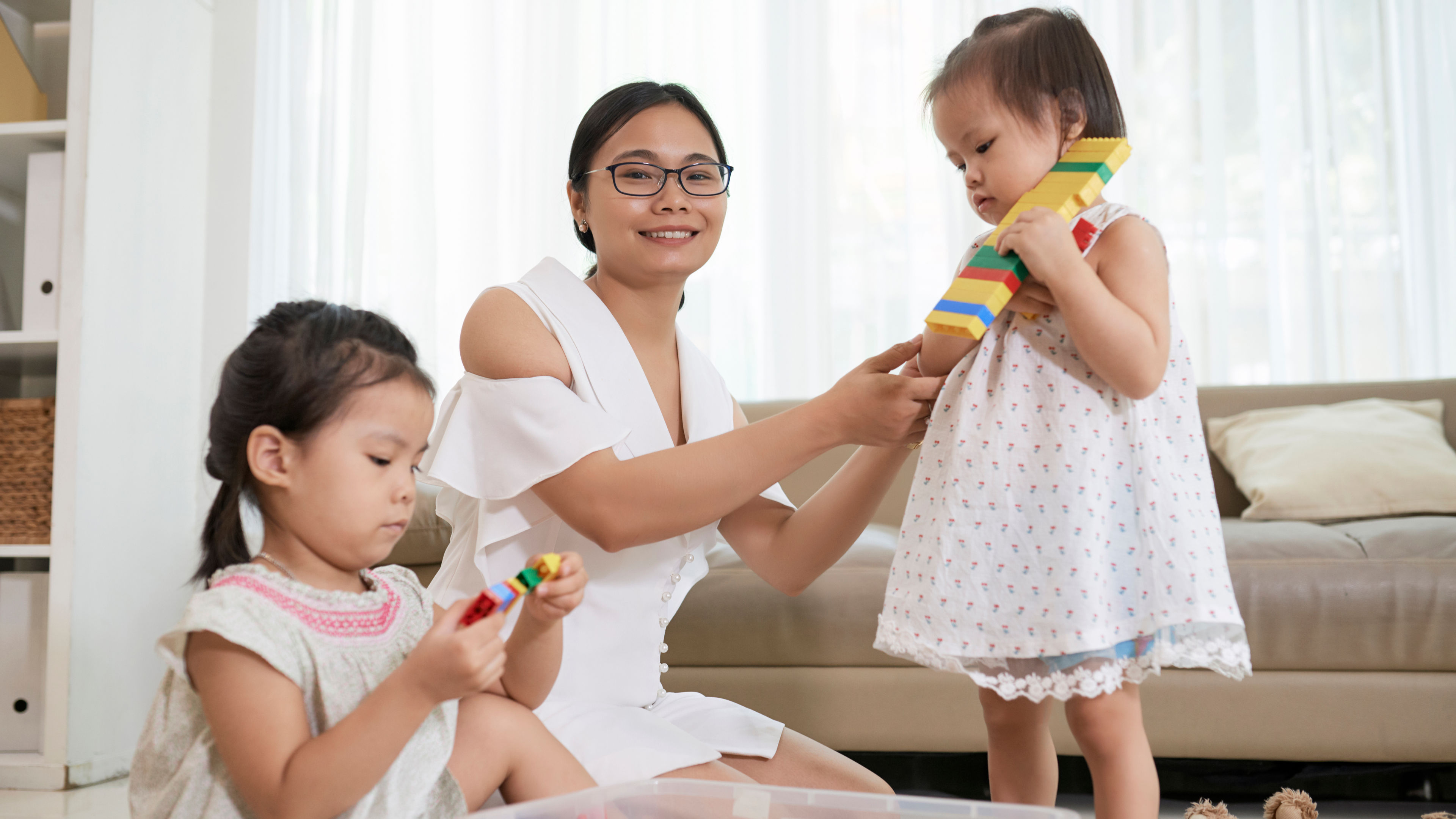 A young woman playing with her daughters 

 