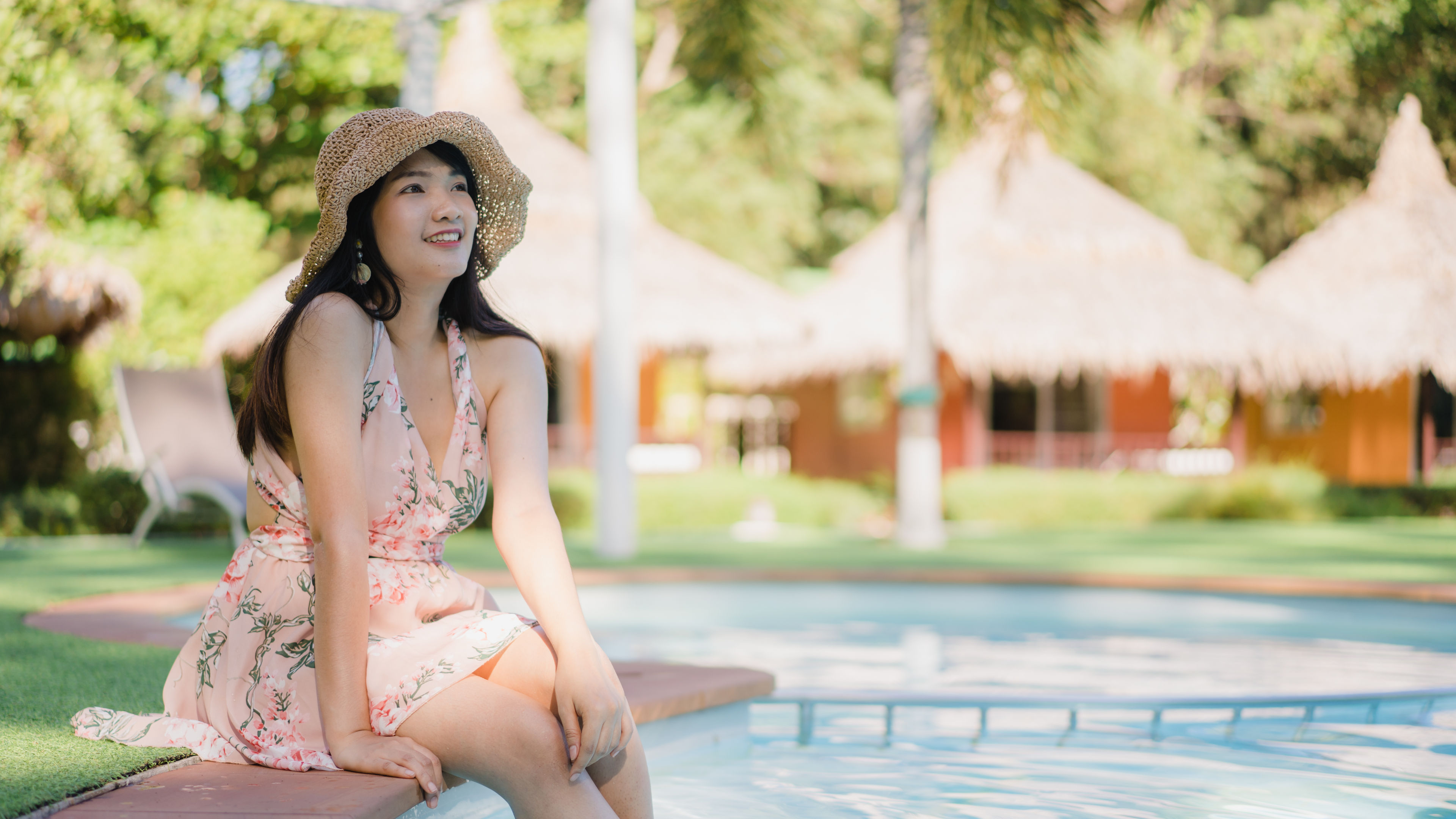 Young Asian woman relax near swimming pool in hotel. 