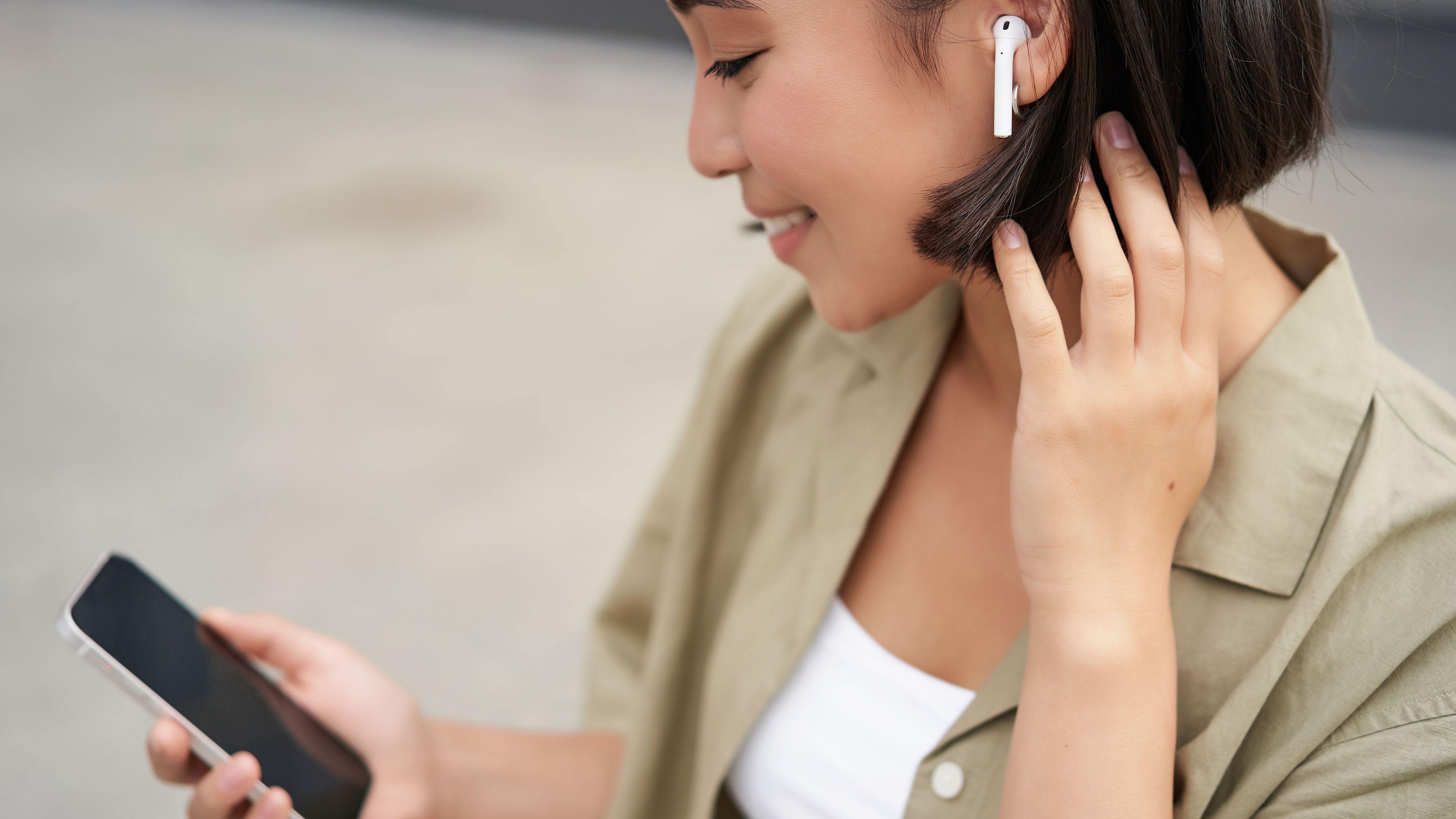 A young woman holding the phone and listening to music