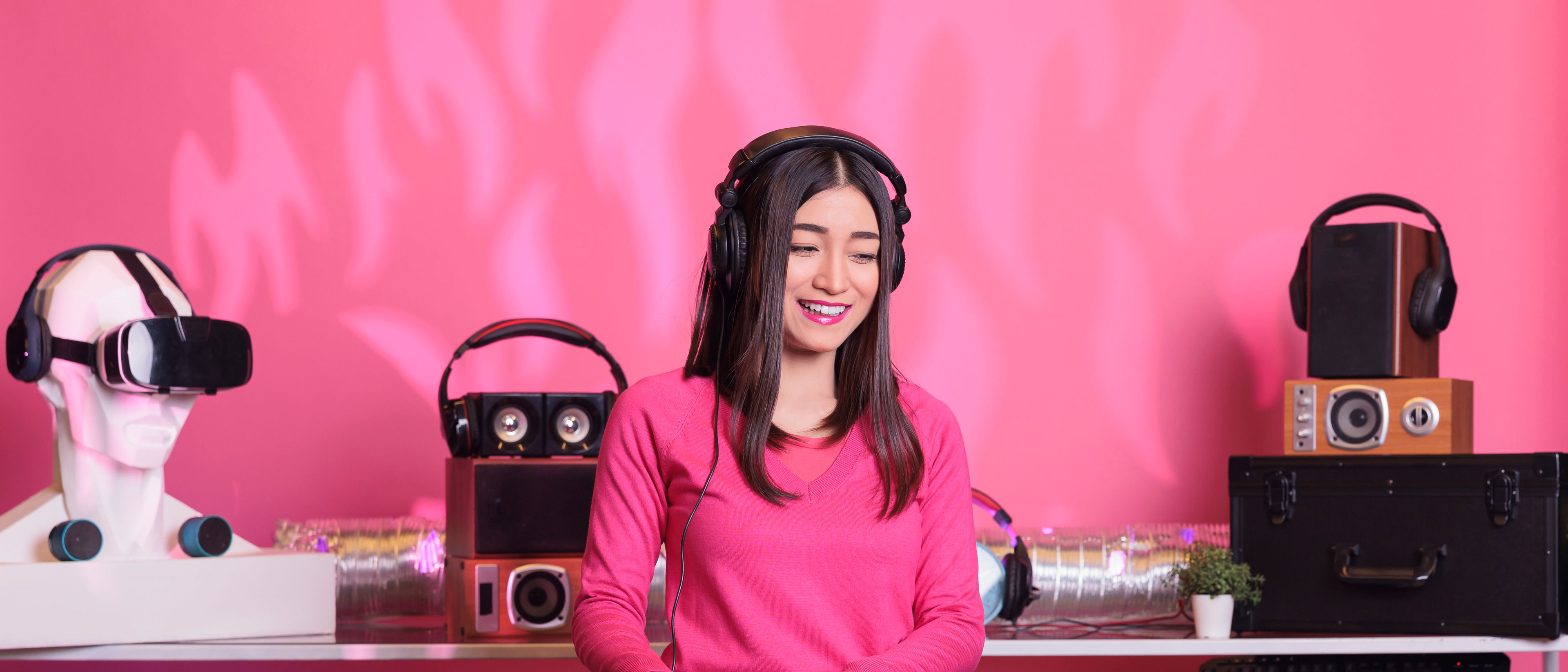 Asian artist performing electronic sound at professional mixer console in studio