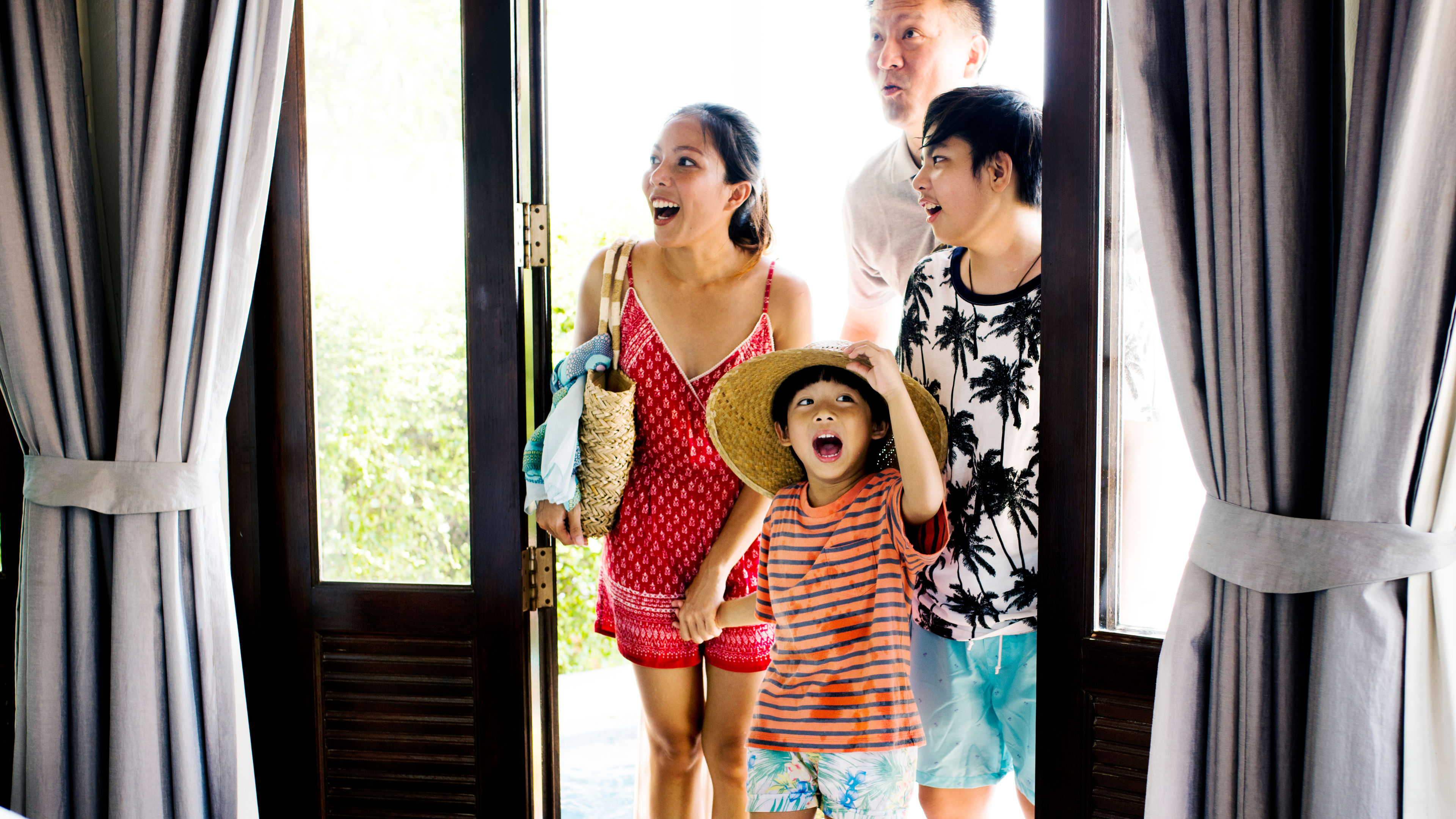 Asian family excited sa pagpasok sa kanilang hotel room