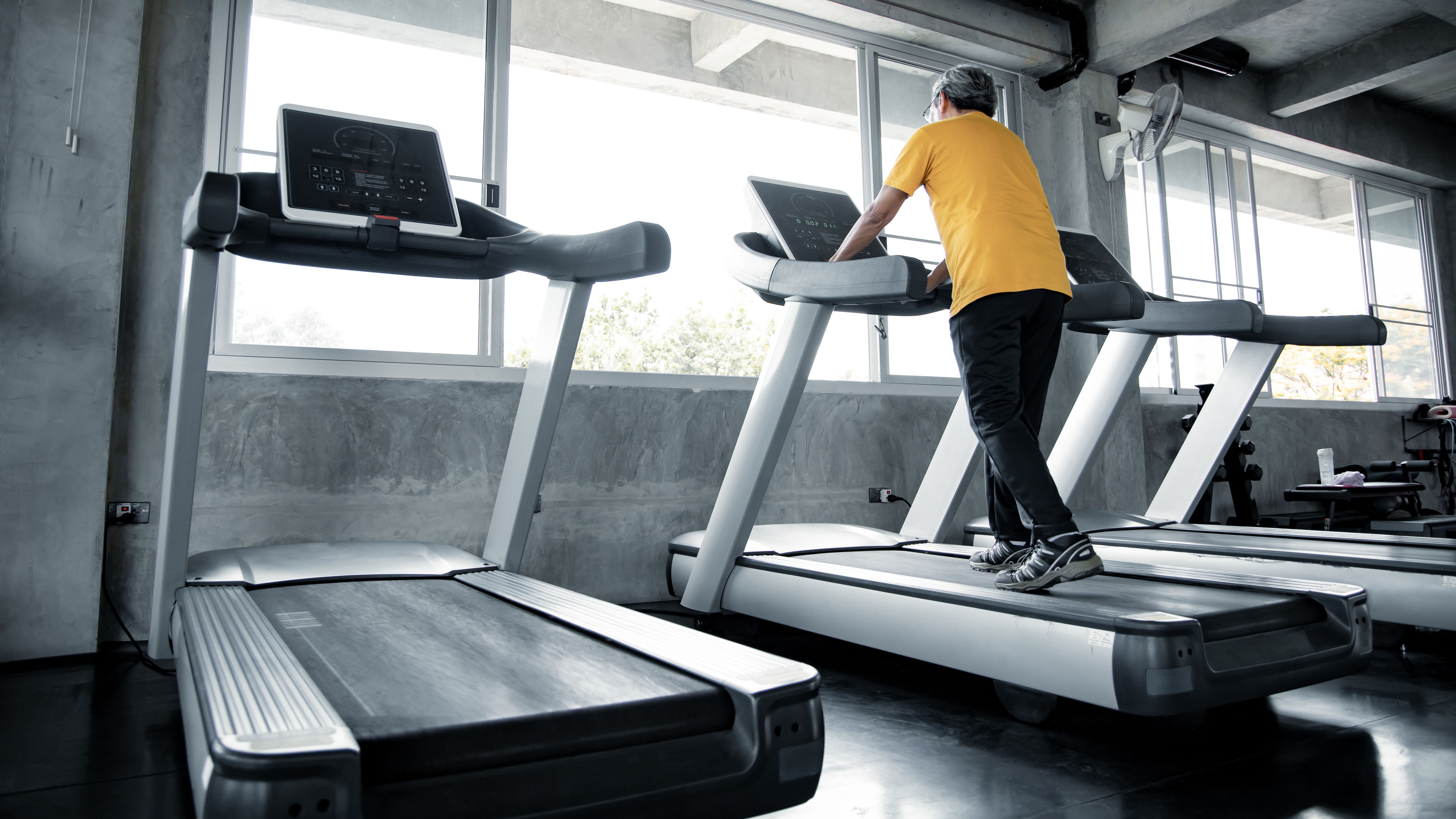 Elderly men are exercising on the running machine in the gym 