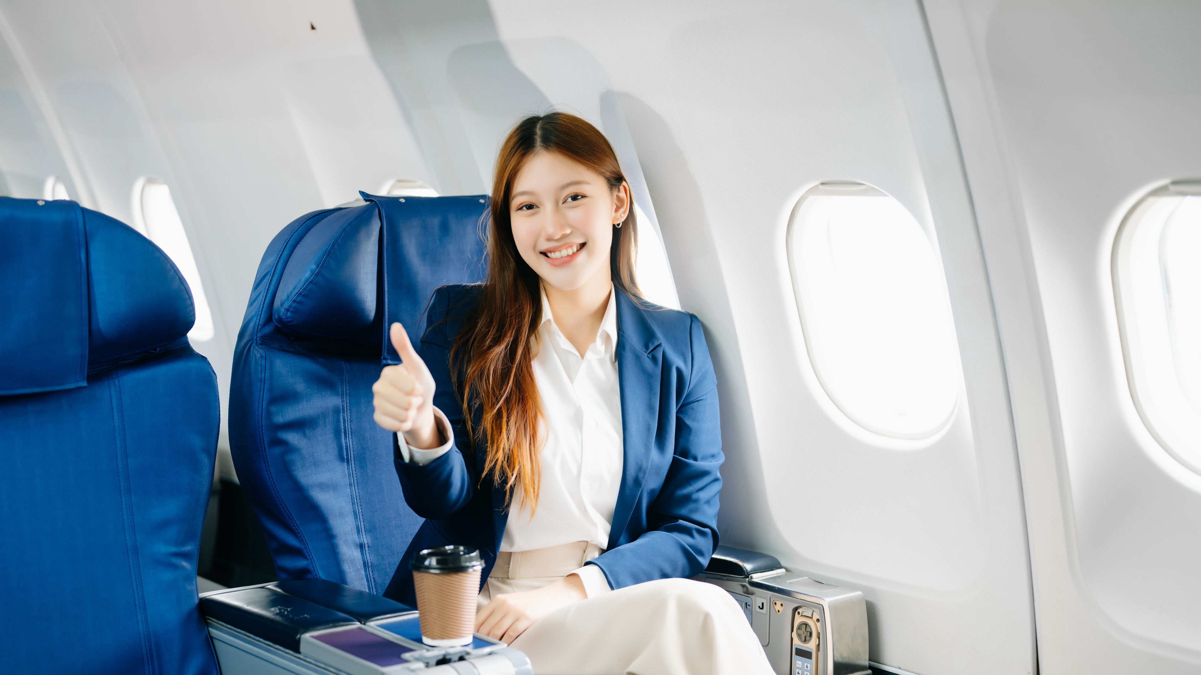 Female passenger of airplane sitting in comfortable seat