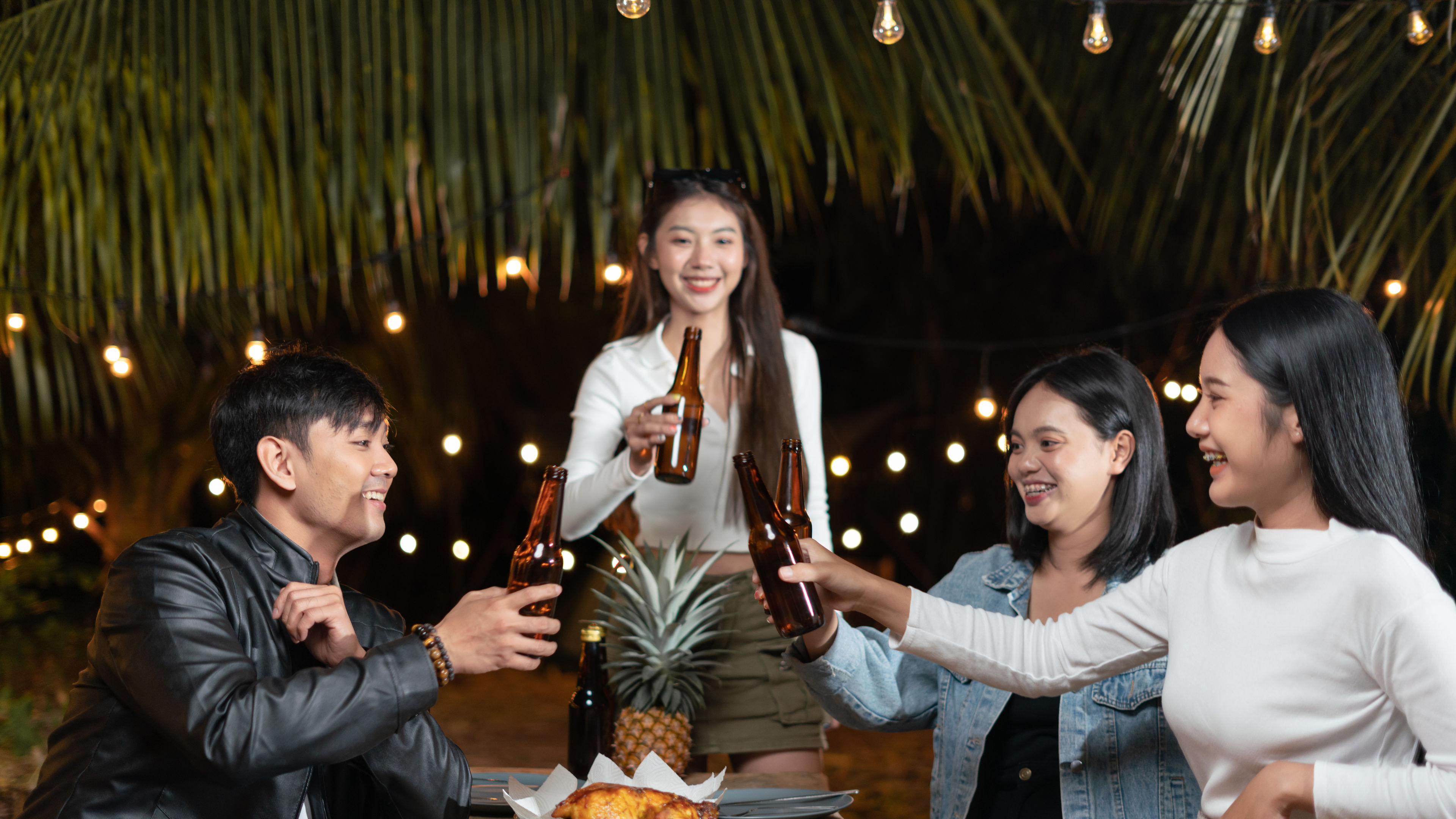 Group of friends drinking beer celebrating a party in the garden 

 