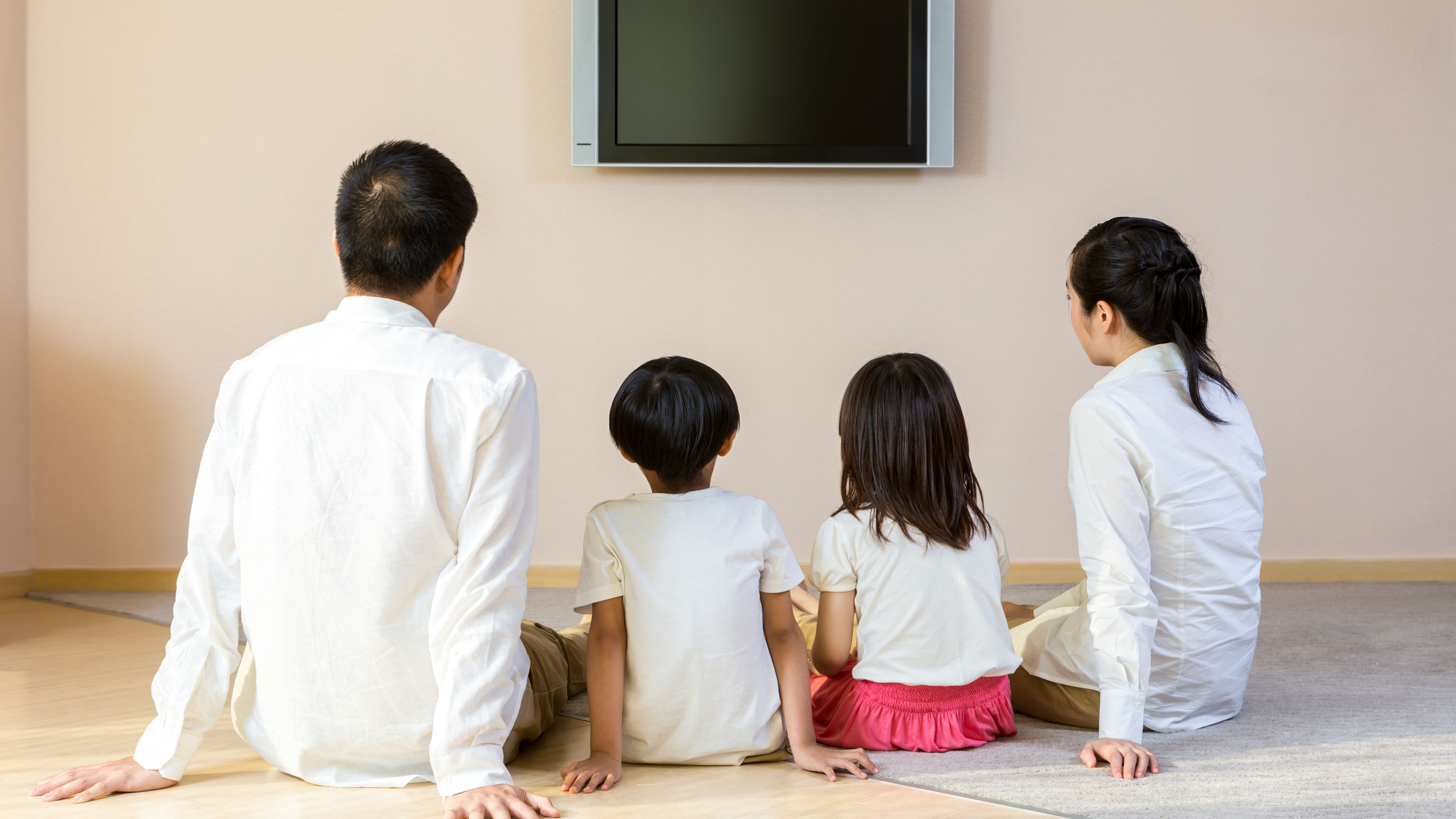 A happy family of four enjoying television 