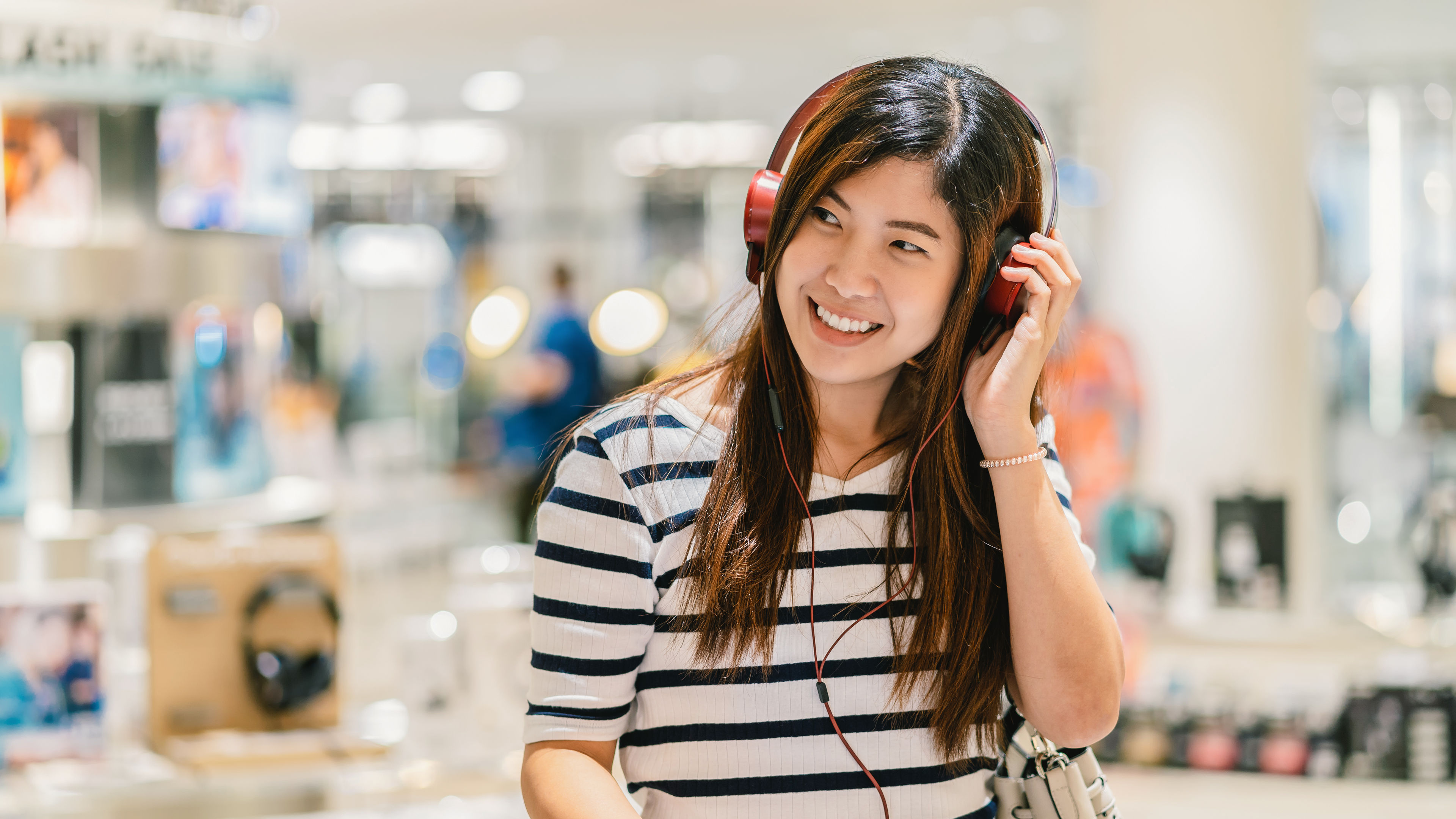 Happy woman testing earphone