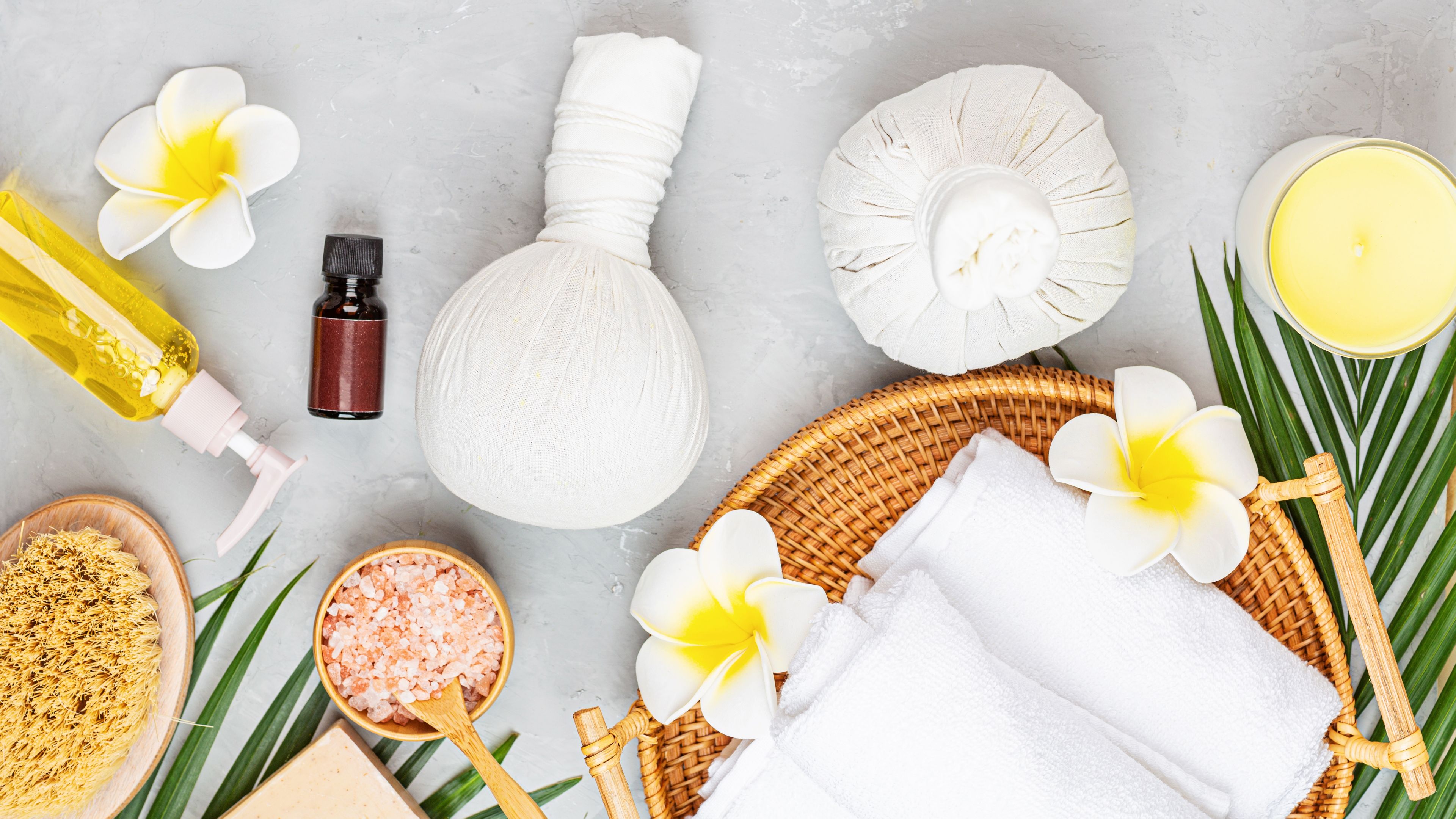 Herbal bags for massage with oil, candle, sea salt, and towels.