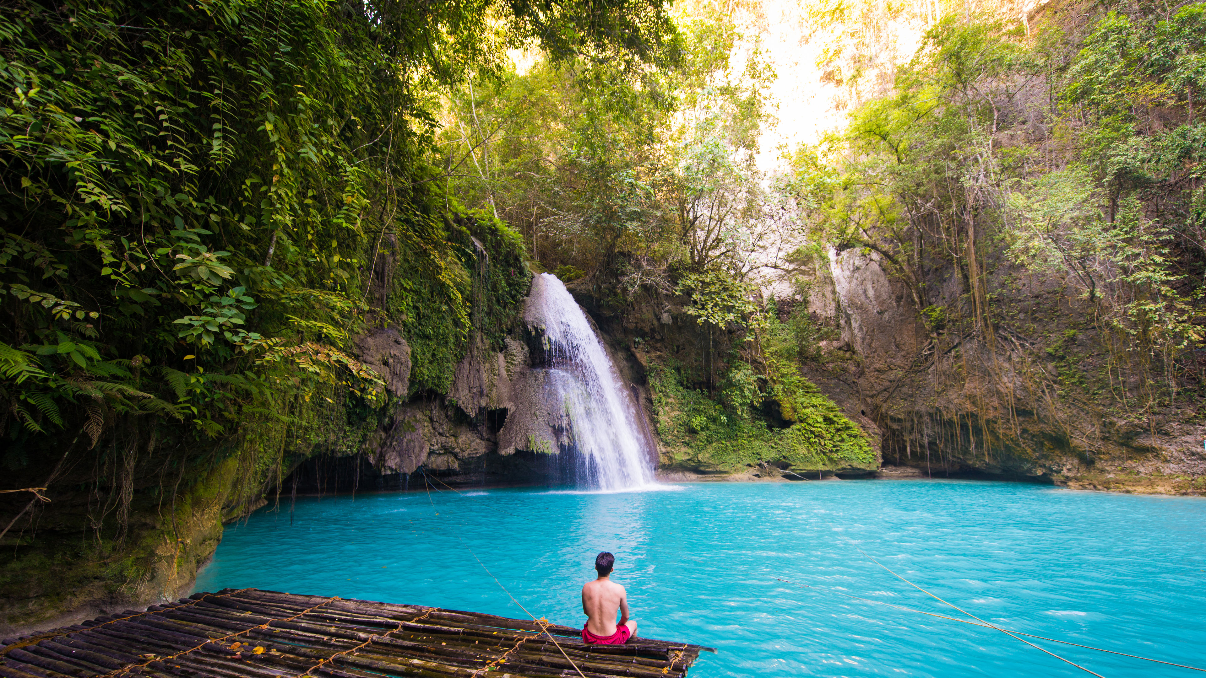 Man sitting and looking at the waterfalls