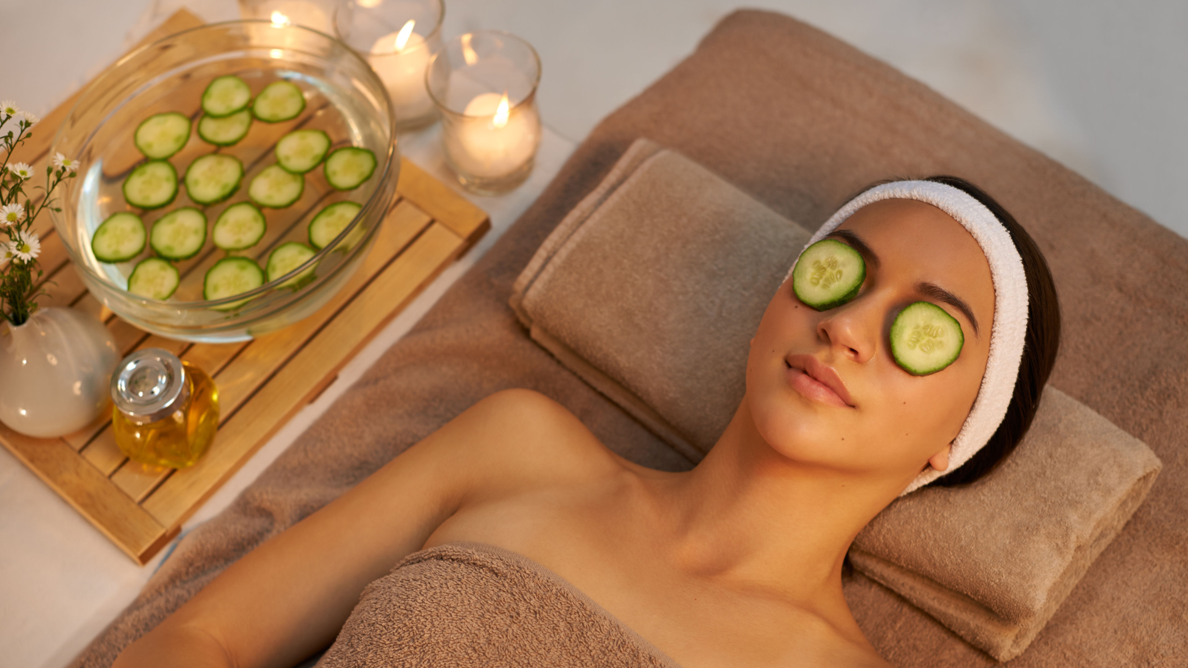 A woman relaxing at a spa with cucumber slices over her eyes. 