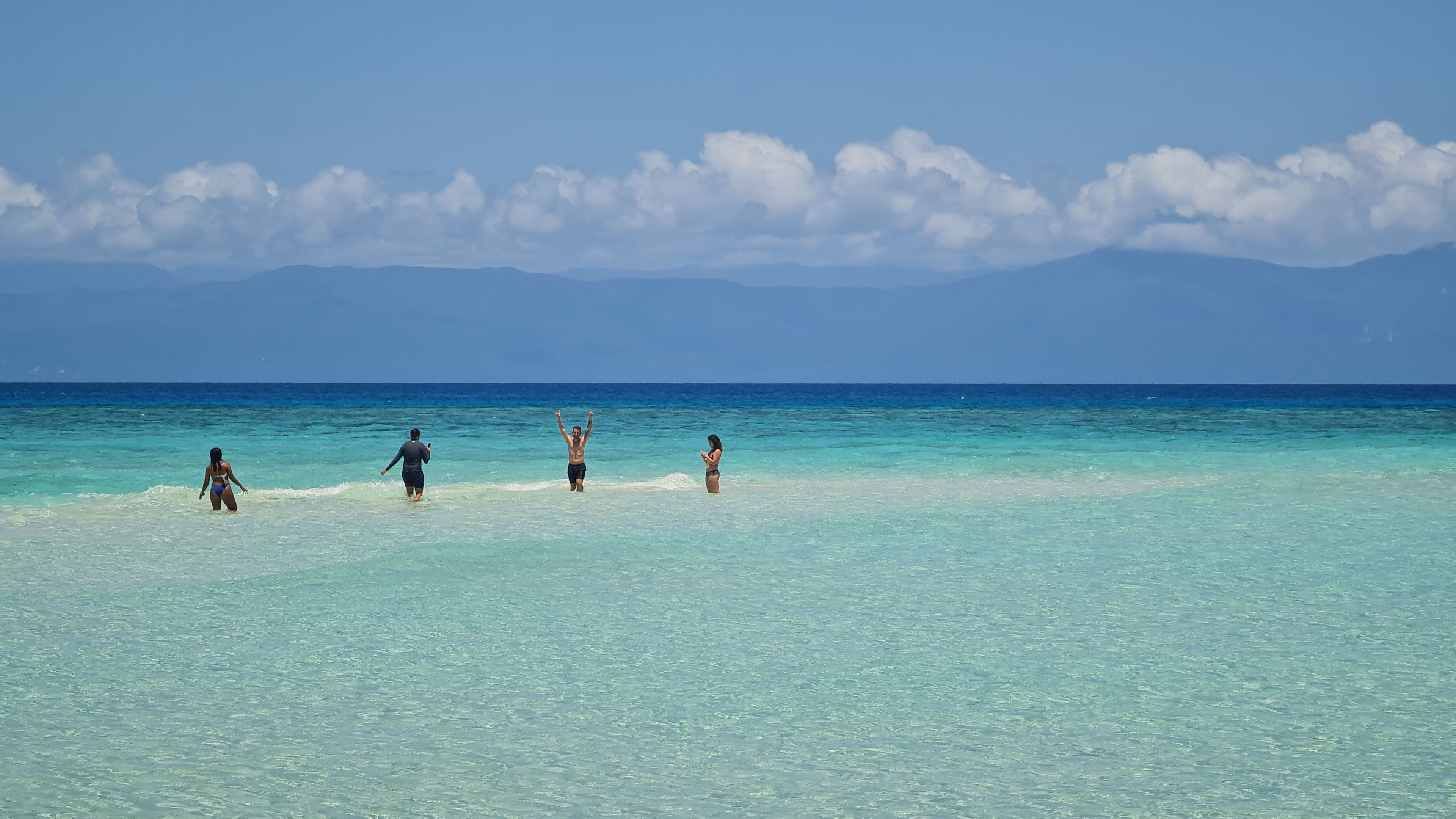 Four friends playing on a beach  