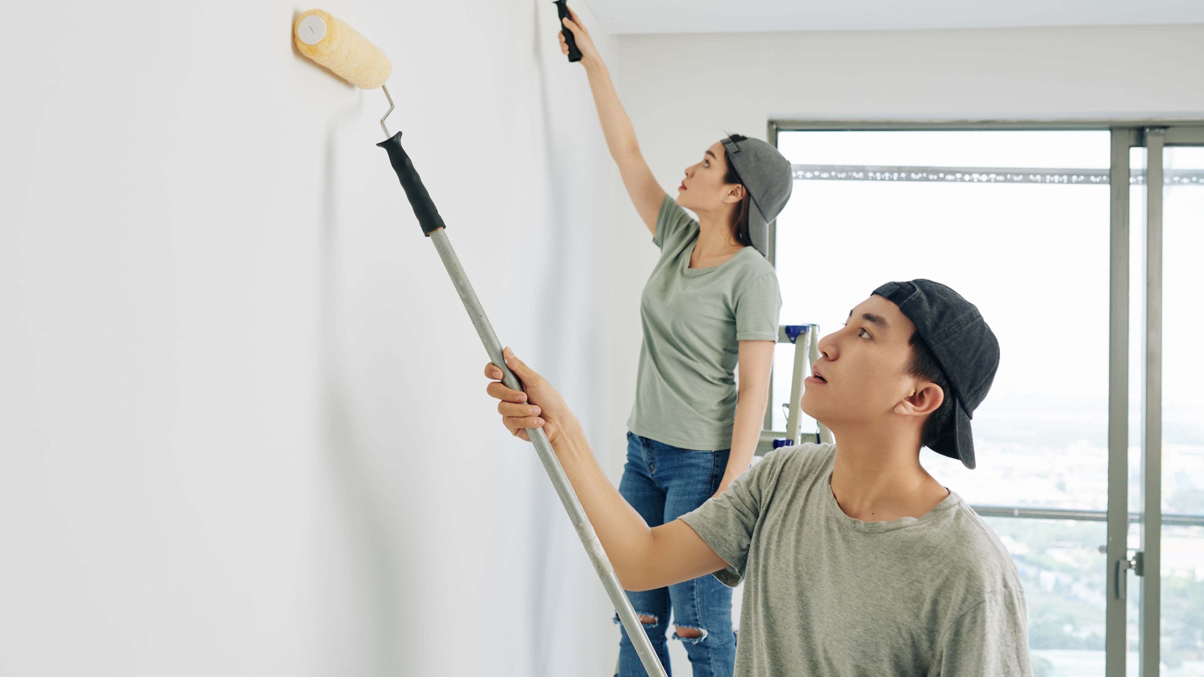 Two people painting a wall 