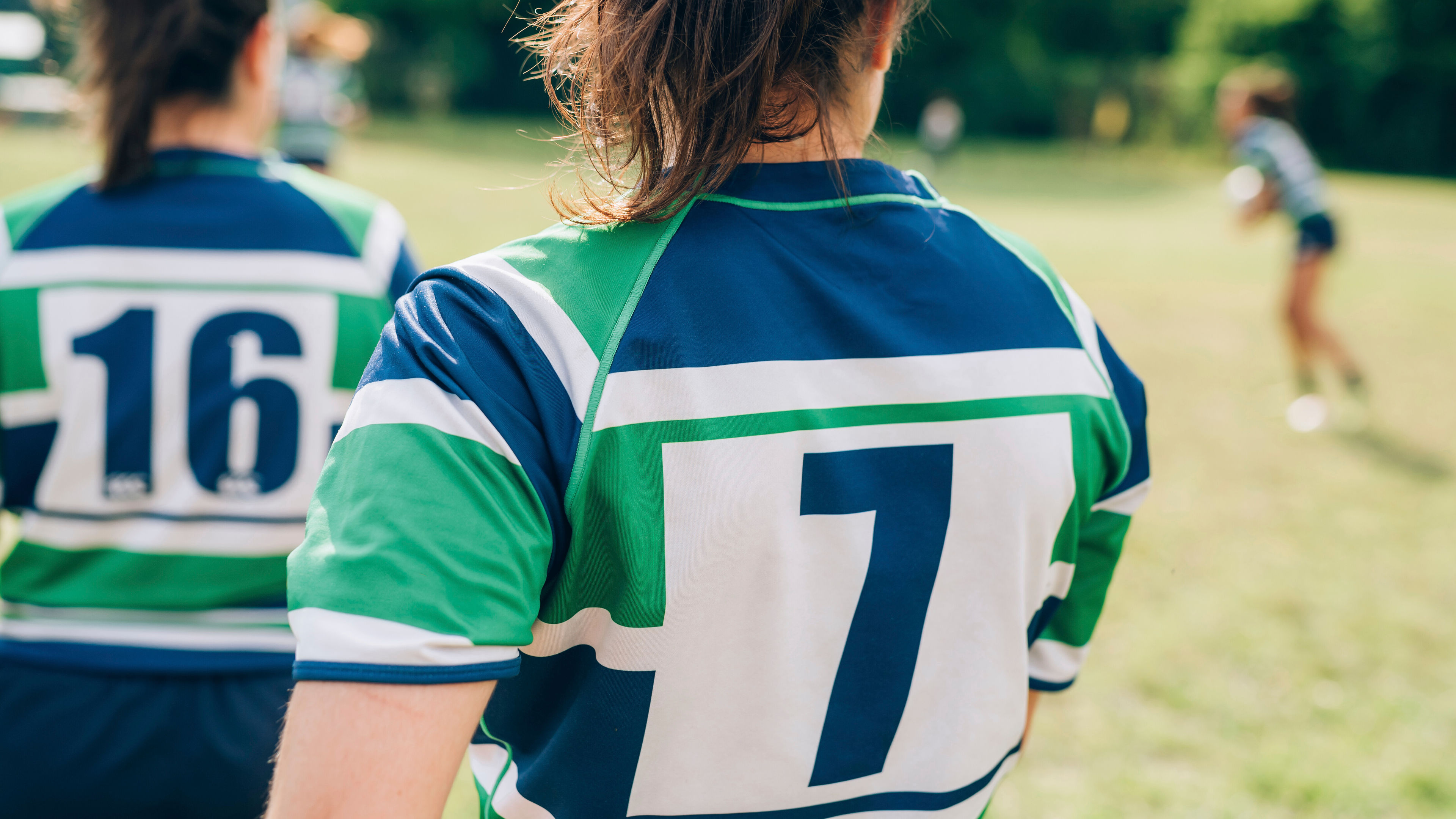 Two women in green and blue rugby jerseys