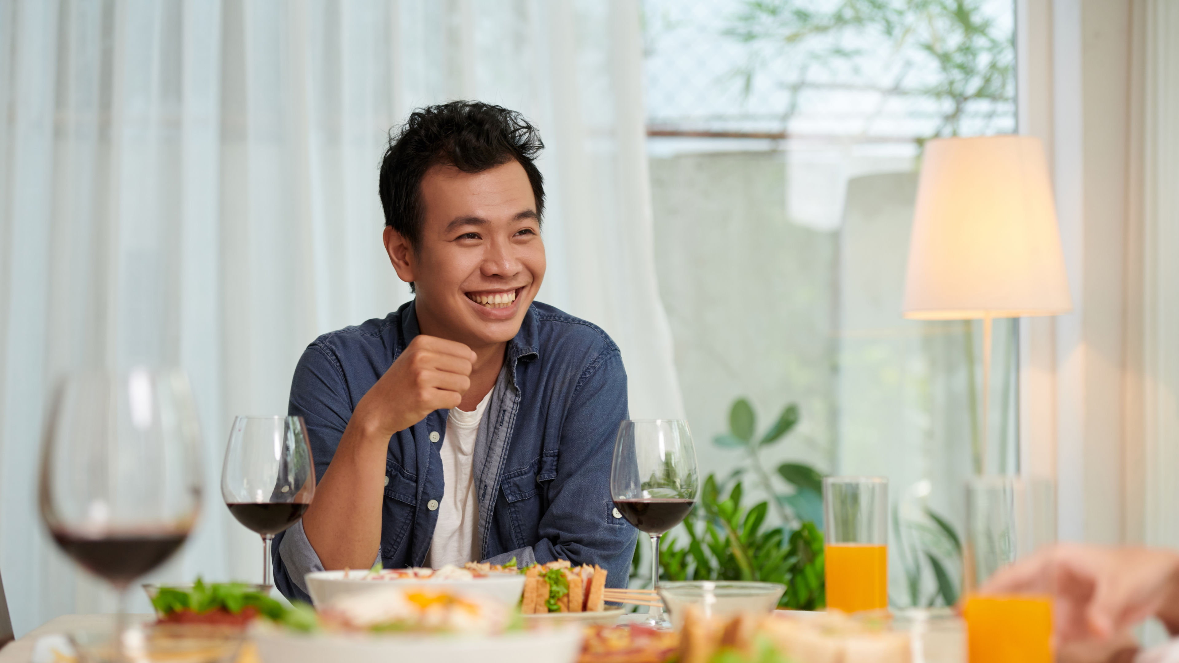 A man is holding a glass of wine, enjoying the moment. 